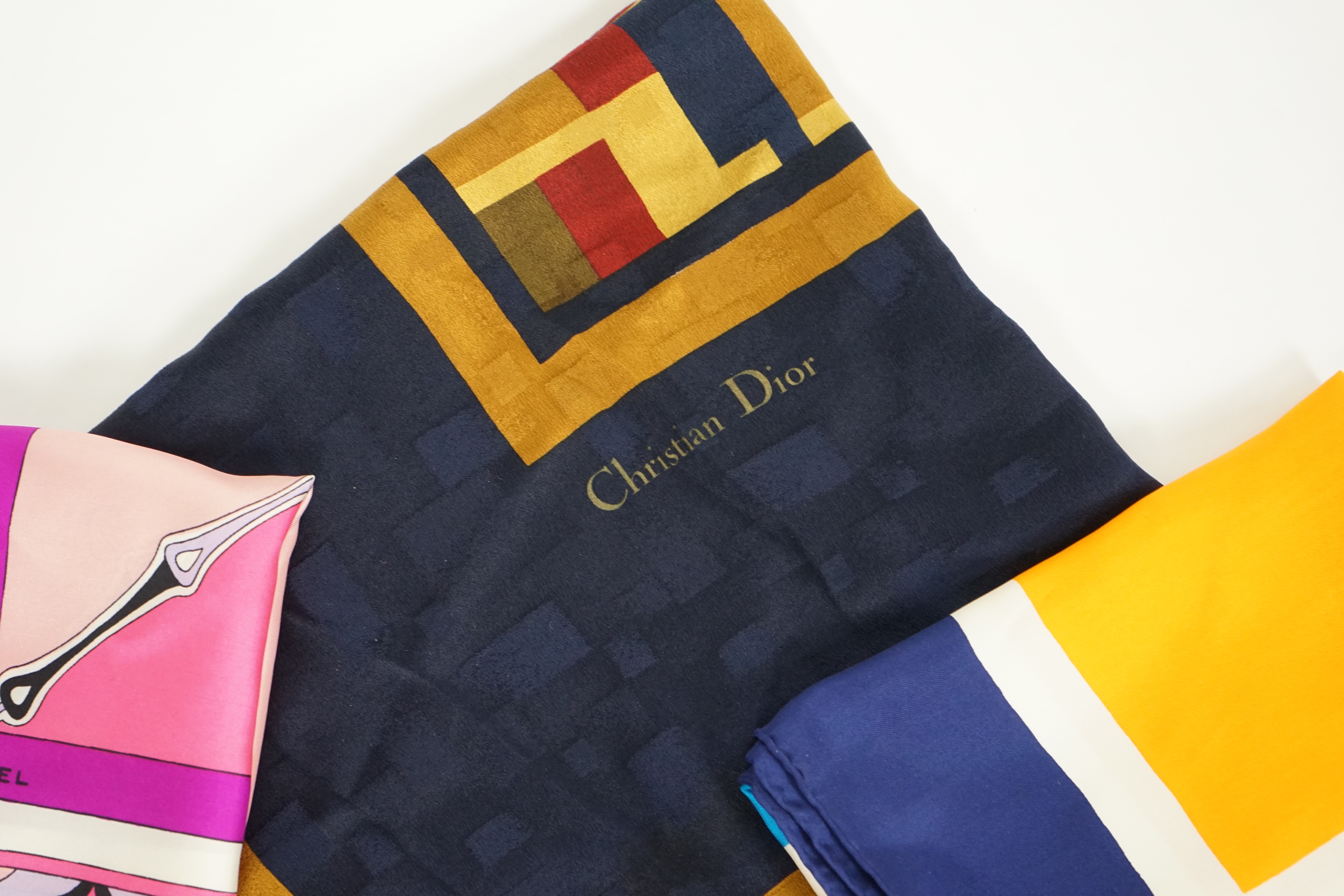 A selection of Yves Saint Laurent, two Christian Dior, Richel and Loewe silk scarves, YSL, 83cm x 85cm Christian Dior: 84cm x 80cm Richel: 87cm x 87cm Loewe: 86cm x 82cm Christian Dior large scarf 120cm x 130cm approx.